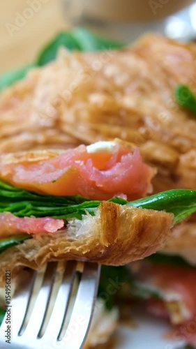 Delicious Croissant Sandwich made with Egg and Avocado and salmon, traditional french cuisine, france cafe, morning breakfast brunch menu. . High quality 4k footage