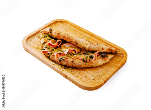 Delicious calzone with ham and herbs on a wooden serving board