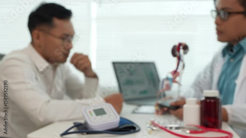 A male patient with a urinary tract infection visits a doctor at a hospital examination table to discuss his symptoms. Talk about an enlarged prostate.