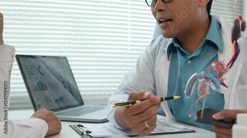 A male patient with a urinary tract infection visits a doctor at a hospital examination table to discuss his symptoms. Talk about an enlarged prostate.