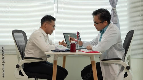 A male patient with a urinary tract infection visits a doctor at a hospital examination table to discuss his symptoms. Talk about an enlarged prostate.