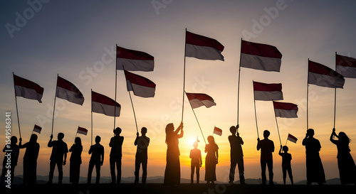 Silhouettes of Patriots Holding Indonesian Flags at Sunrise
