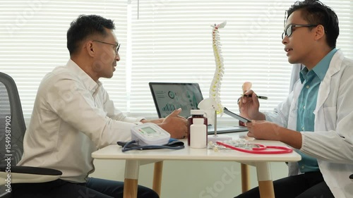 Male patient complaining of back pain listens to the clinic, focusing on physical therapy, spine doctors for rehabilitation, counseling and exercise, health care and those who are with the patient to 