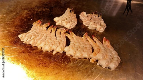 shrimps are fried on a teppanyaki cooker