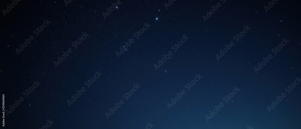 Fototapeta premium Starry night sky with twinkling stars and deep blue background creates serene atmosphere, perfect for stargazing and reflection