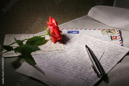 Still life with a letter and a pink rose