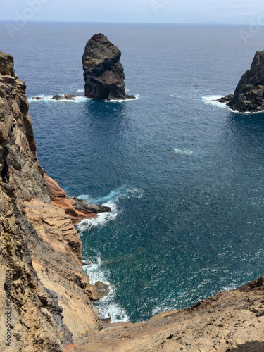 Ocean waves crashing against huge rocky mountains on coast of Madeira, Portugal. Seascape with white surf, sea spray and rocks
