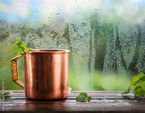 copper mug drink glistens refreshing beverage by rain streaked window