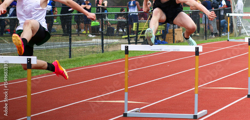 Athletes Hurdling at an Outdoor Track Meet
