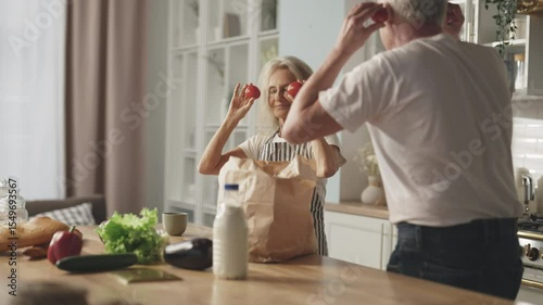 Calm and happy sunday morning in kitchen, joyful old spouses unpacking eco bag. Healthy nutrition and diet for stay active in old age, low-calories and tasty food from eco farm, food delivery service