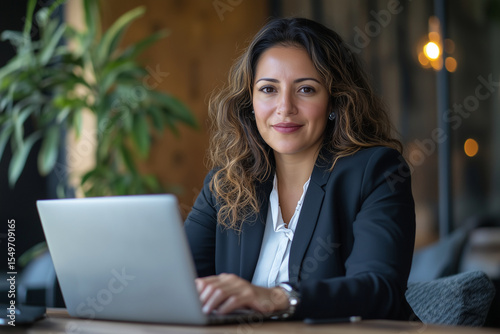 Colombian businesswoman working with laptop in modern office
