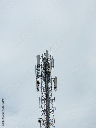 Telecommunication tower with metal antenna structure standing tall under a cloudy sky