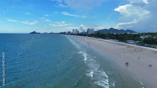 Long sandy beach with skyline and ocean waves