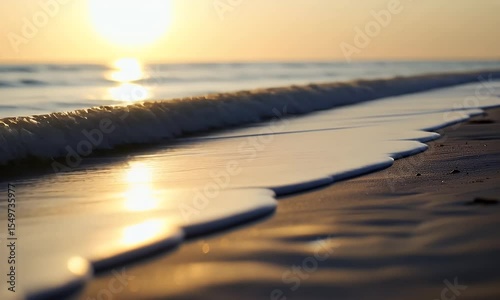 Golden Sunset at Tranquil Beach with Gentle Waves Washing onto the Shoreline Warm Sunlight Illuminating Soft Focus Sand