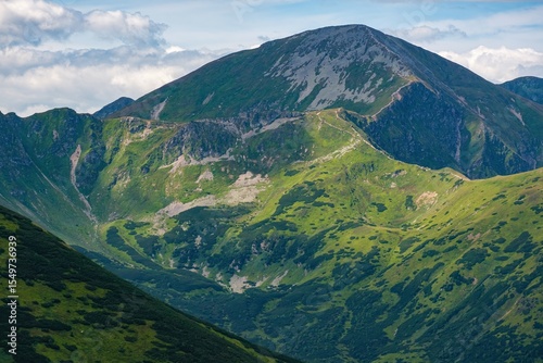 Wild untouched mountain range, deep green valleys. View on peak in the West Tatra Mountains. Beautiful landscape in mountain. Summer hiking and healthy lifestyle.