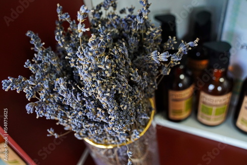 Lavender flowers with natural hair care products in background. Organic beauty concept with shampoo, conditioner, and herbal ingredients. Spa, wellness, eco-friendly lifestyle.