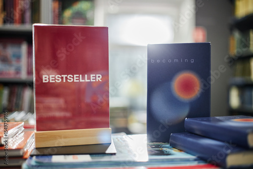 Принти на полотні Stack of books on display in bookstore with red book labeled Bestseller standing