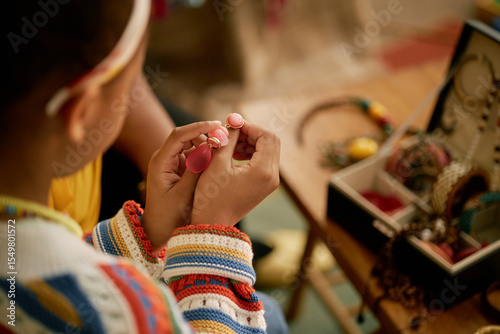 Принти на полотні Close up of childs hands holding piece of colorful earrings organizing accessori