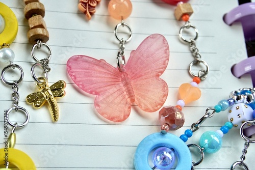 Canvas Print Colorful orange red butterfly beads isolated on horizontal note book lined paper and bag charm accessories background