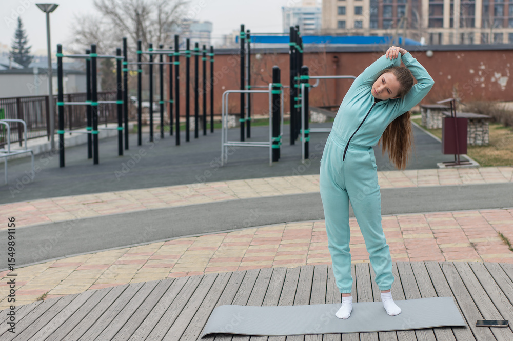 Fototapeta premium Young woman doing fitness outdoors.