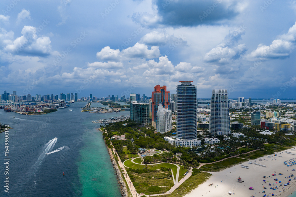 Obraz premium Aerial night view of Miami coastline. Twilight skyline above the Miami oceanfront. Miami Beach waterfront glowing after sunset. Famous Miami Beach from above.