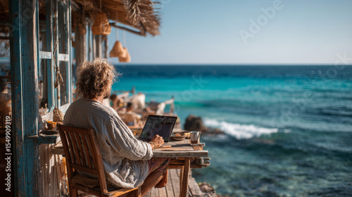 A content freelancer works remotely on the beach with a laptop, living out the dream of an ideal work-life balance at a picturesque seaside office