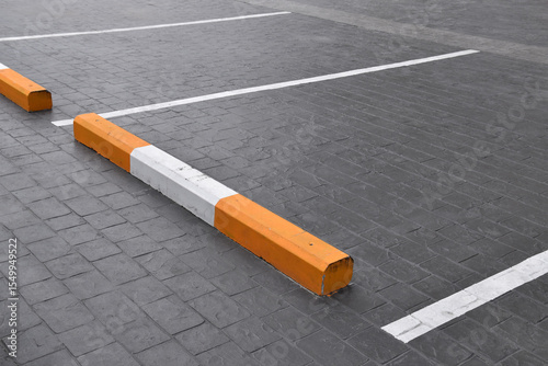 empty parking lot with wheel stopper on paved surface