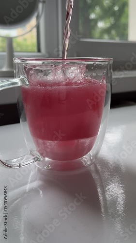 Wallpaper Mural pouring into a cup with ice pink juice soda refreshing semi-sweet on a white table Torontodigital.ca