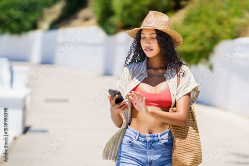 A Stylish Woman in a Chic Summer Outfit is Enjoying a Relaxing Day Outdoors with Her Smartphone