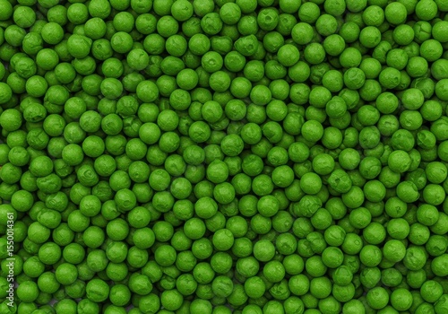 An overhead view of numerous fresh, green peas creating a rich, detailed surface.