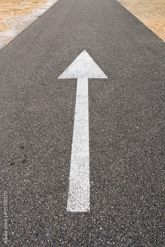 arrow straight ahead on asphalt road