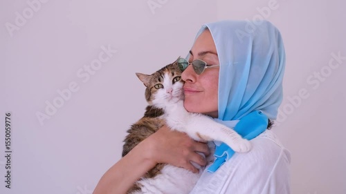 Headscarf-wearing woman loves her cat. Muslim people  or family lifestyle examples