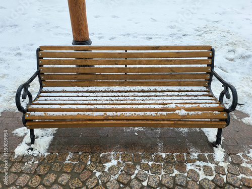 Brown wooden secluded bench in the snow. Perfect for seasonal solitude, peaceful moments, and contemplative scenes.