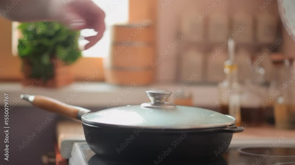 hand closes glass lid in which steak osso buco with vegetables is being fried. High quality 4k footage