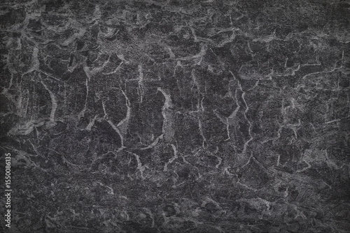Texture of black polished concrete background. Dark plaster wallpaper with rough cement texture. Empty grunge wall concept or floor backdrop. Abstract surface mockup. Top view, close up, copy space