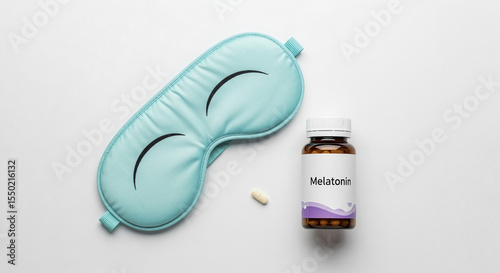 Sleep mask near melatonin bottle and tablet on white background  