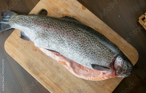 Freshly caught rainbow trout displayed on a wooden cutting board ready for preparation