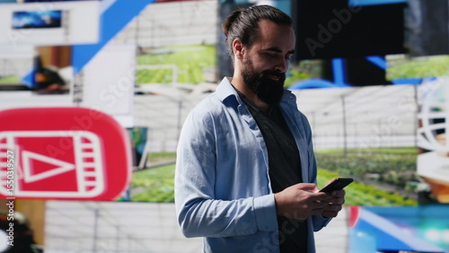 Modern online lifestyle of a young man checking real time notifications, enjoying interaction with followers and posting creative content in a social network environment. Camera A.
