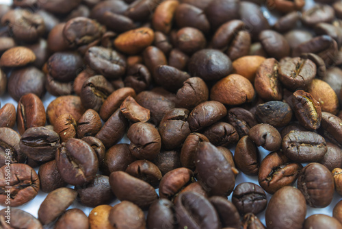 Top view background of aromatic brown coffee beans scattered on surface.