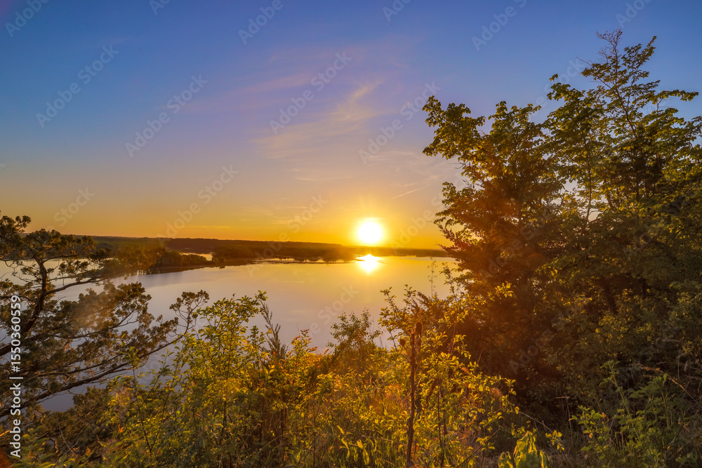Sunset Over Tranquil Lake with Forested Shoreline Sunset Over Tranquil Lake with Forested Shoreline