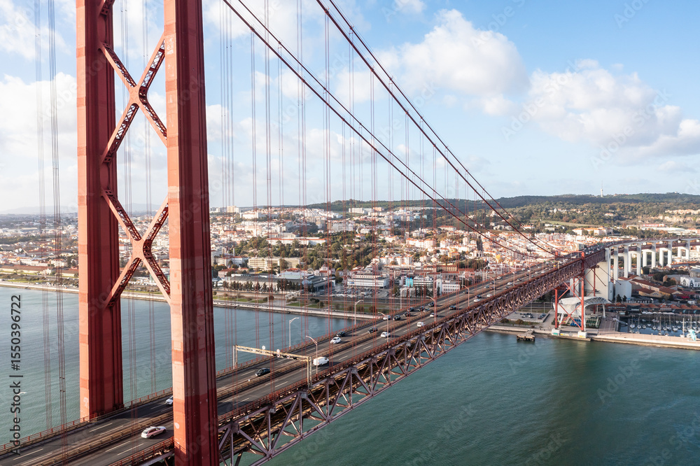 Naklejka premium Aerial view of cars crossing the 25 de abril bridge in Lisbon, Portugal.