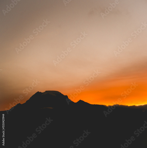 Atardecer sobre silueta de montaña con cielo anaranjado en los Andes