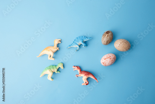 Fototapeta Naklejka Na Ścianę i Meble -  dinosaur toys in various poses on light blue surface for preschool education, creative visuals, toy shop promotions, children blogs, science-themed learning kits, digital content projects