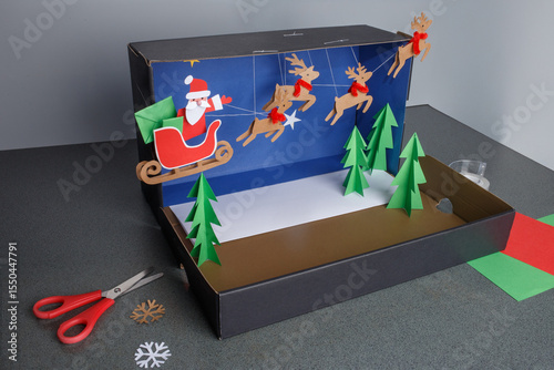 a step-by-step visual guide for making a Christmas-themed diorama using paper crafts. shoebox as the base and decorating it with colored paper, A fun, creative, and simple DIY holiday project