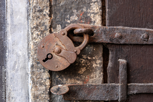 Vintage rustic padlock on weathered metal door