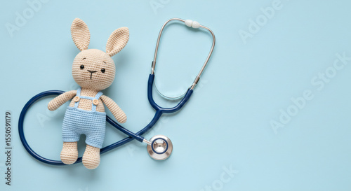 Pediatrics concept, Toy bunny with stethoscope on light blue background, top view 01