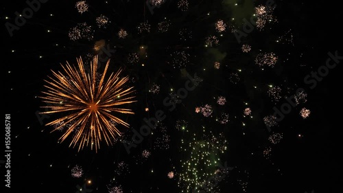 Breathtaking fireworks bursts in black night sky on holiday. Dazzling display with burning firework traces against darkness during performance. Fireworks amuse holiday event audience in dark night