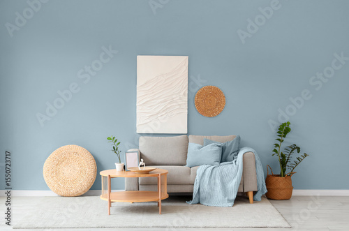 Sofa and wooden coffee table near white wall in interior of living room