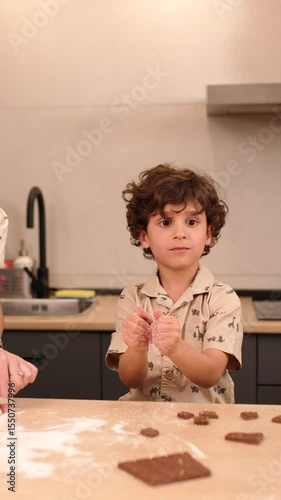Young boy making chocolate cookies in modern kitchen