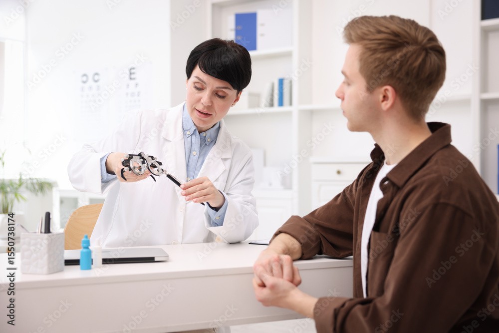 Obraz premium Ophthalmologist consulting young man at white table in clinic
